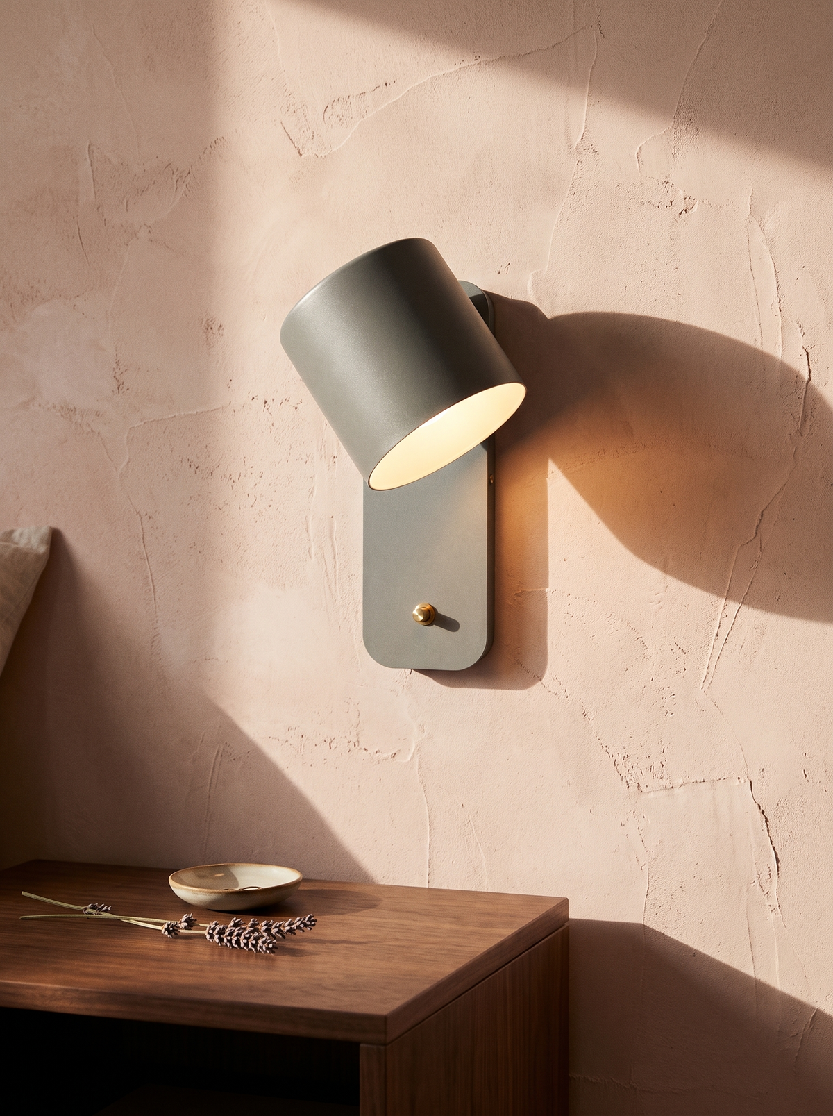 Tate swivel cylinder wall lamp in grey on a blush plaster wall