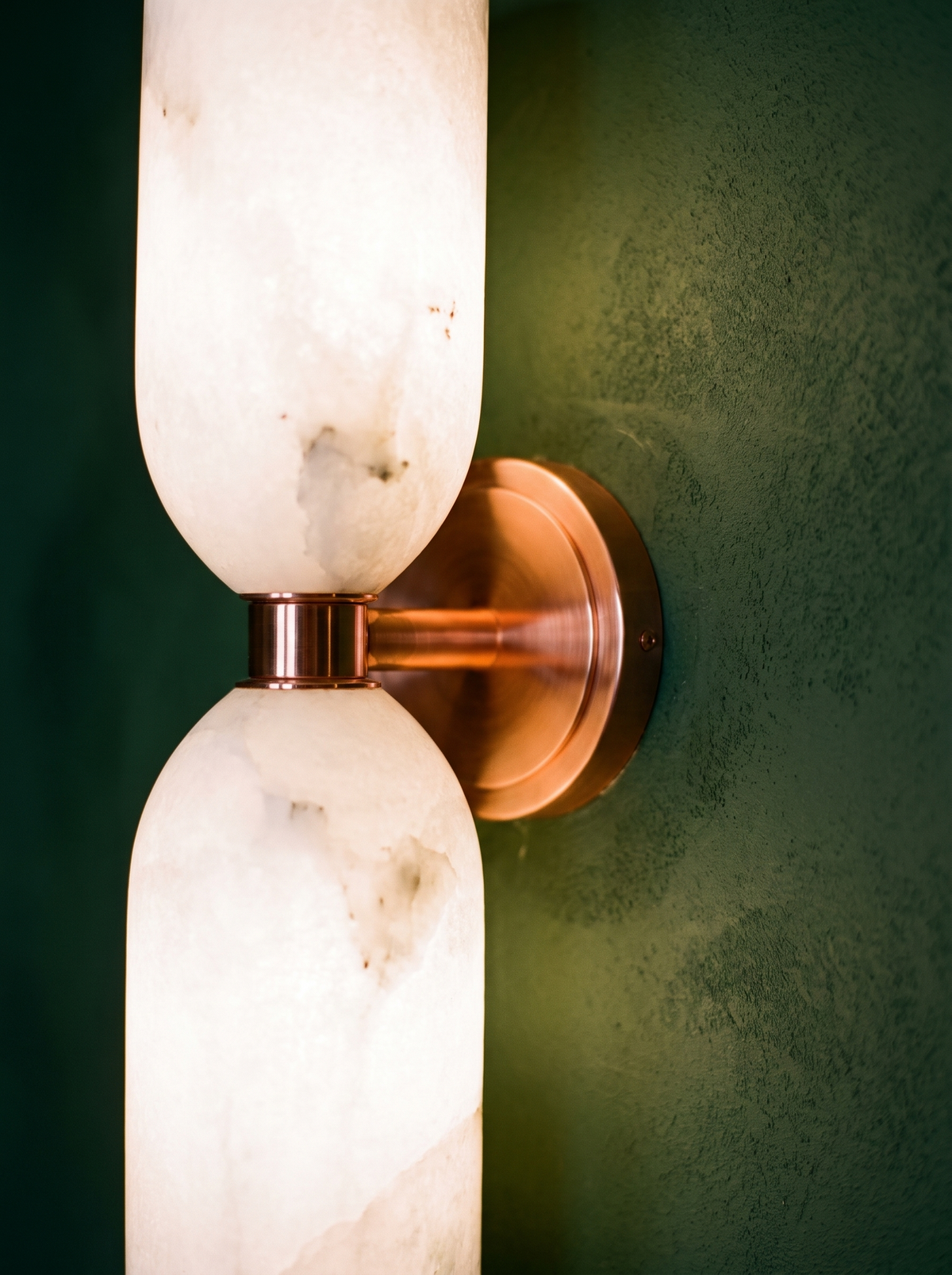 Lifestyle: close-up of Nyx's copper collar between the alabaster columns