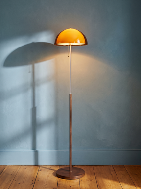 Briar amber mushroom floor lamp in walnut on a dusty-blue plaster wall