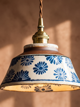 Lifestyle: close-up of Delft's hand-painted blue daisy ceramic and brass fitting, lit