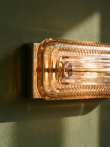 Lifestyle: close-up of Calla's ribbed cognac glass and brass mount, lit