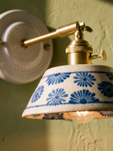 Lifestyle: close-up of Fable's hand-glazed blue daisy ceramic and brass arm, lit