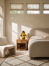 Lifestyle: Petal green glass table lamp on an oak nightstand in a cream plaster bedroom, showing its size