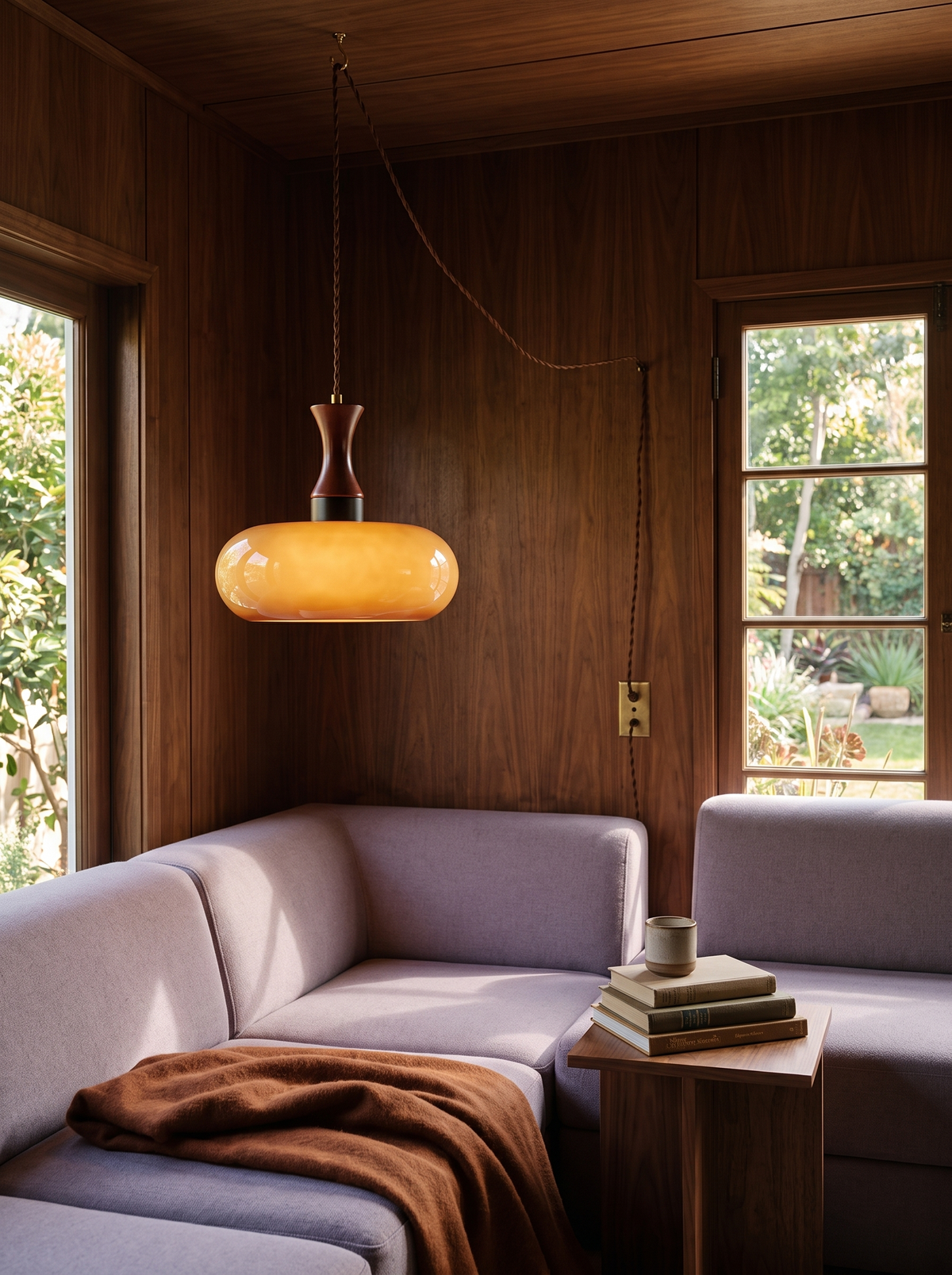 Lifestyle: Toffee caramel glass plug-in pendant beside a lilac sofa in a walnut-panelled den