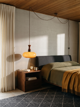 Lifestyle: Toffee plug-in pendant hung as a bedside light in a grasscloth bedroom, showing its size