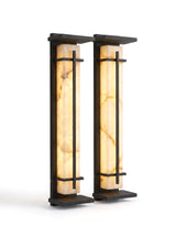 A matched pair of Luminara sconces on white, glowing warm