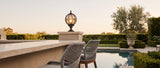 Lune pillar lantern with woven-rope bar stools, wide poolside terrace at golden hour — lifestyle