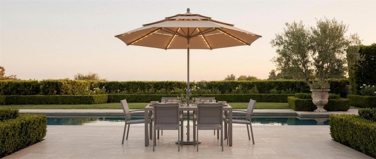 Sera umbrella with lit solar ribs over a poolside dining set at dusk — lifestyle