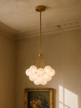 Perle 19-globe frosted glass bubble chandelier in gold in a plaster-moulded corner