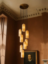 Sola nine-pendant alabaster cluster pendant in brass in a sienna plaster corner