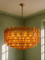 Soleil 37.4-inch amber glass disc chandelier hanging in a plaster-moulded corner