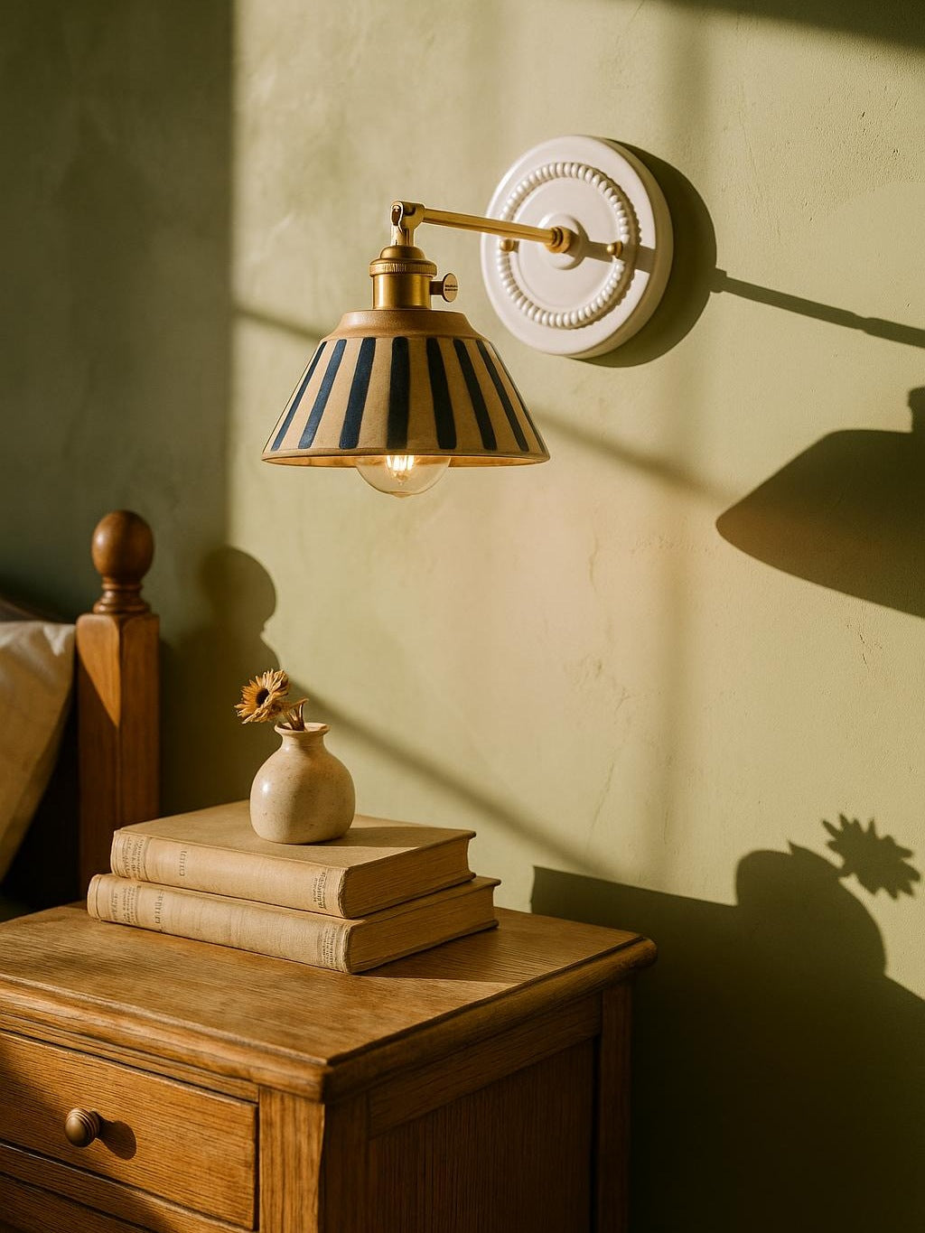 Fable blue stripe ceramic wall sconce in brass on a pistachio plaster wall