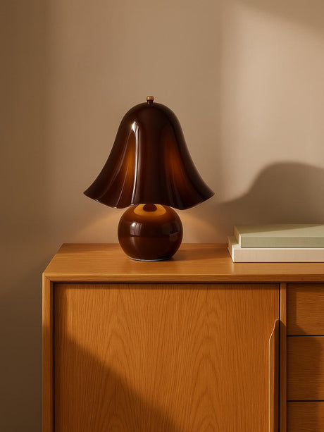 Petal brown glass flower table lamp without beads on an oak console against a warm plaster wall