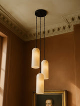 Sola three-pendant alabaster cluster pendant in black in a sienna plaster corner