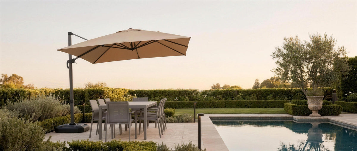 Belvara umbrella shading a poolside dining set at golden hour — lifestyle